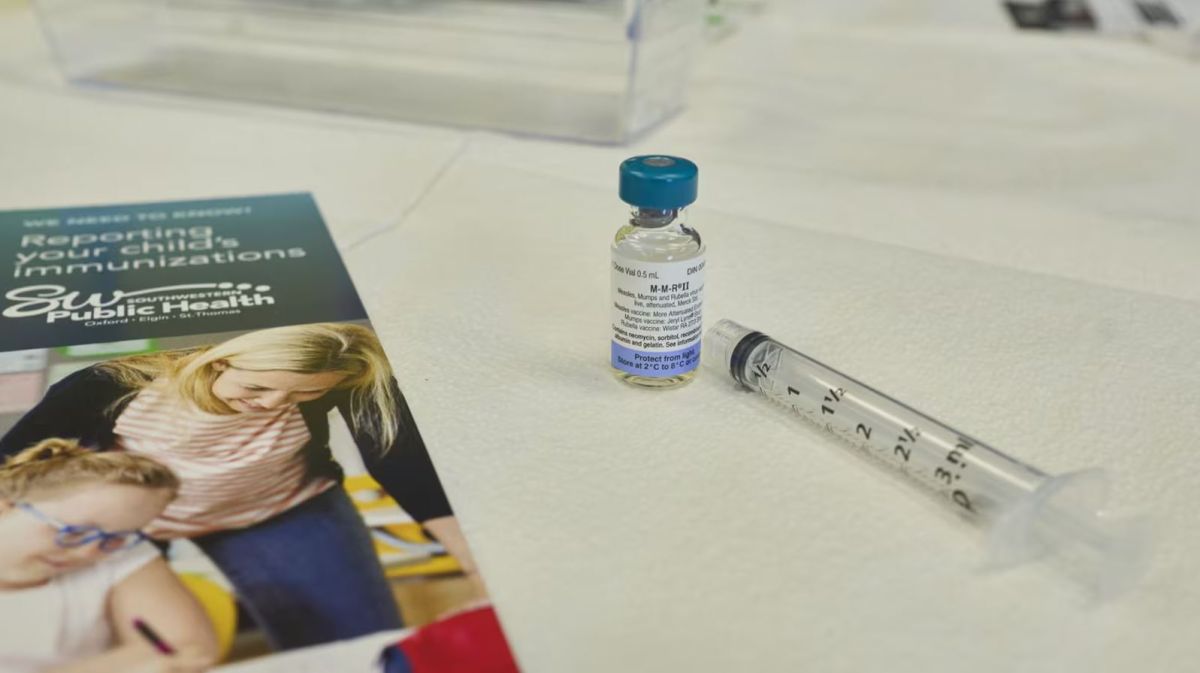 Информационный плакат PAHO о симптомах кори в медицинском центре.