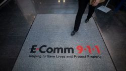 Сотрудник диспетчерской службы экстренной помощи E-Comm в Британской Колумбии за рабочим местом с картой.