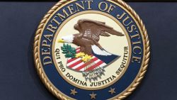 Seal of the U.S. Department of Justice featuring a bald eagle with olive branch and arrows, shield, and Latin motto in a blue circular border with a gold rope edge.