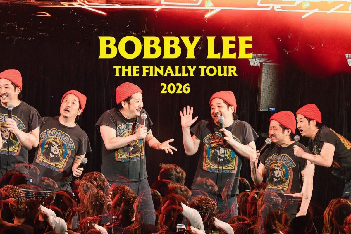 Stage performance photo of comedians in red beanies and black shirts with 'BOBBY LEE THE FINALLY TOUR 2026' headline above them and a cheering audience in front.