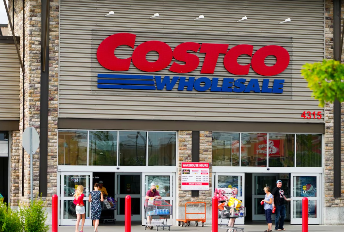 Costco Wholesale storefront with shoppers and shopping carts outside the entrance.