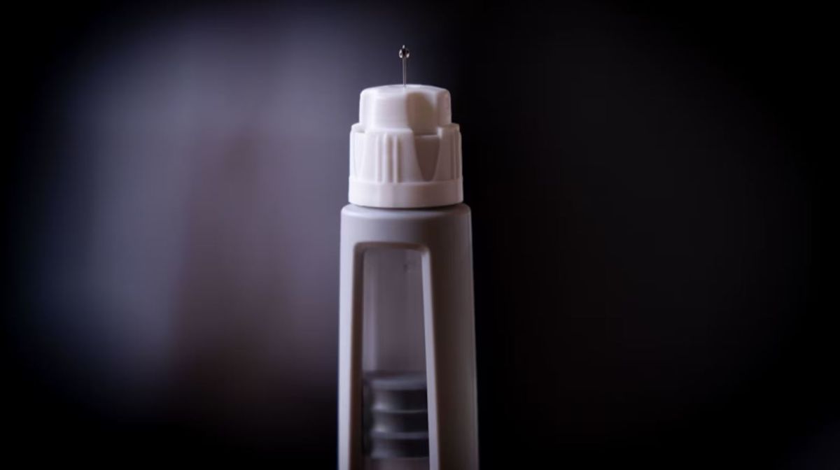 Фармацевтическая компания | Наш Ванкувер Close-up of a white medical injection pen with the needle exposed against a dark background.
