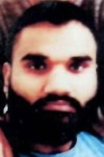 Голди Брэр | Наш Ванкувер Close-up of a man with dark hair and a full beard, wearing a blue shirt.