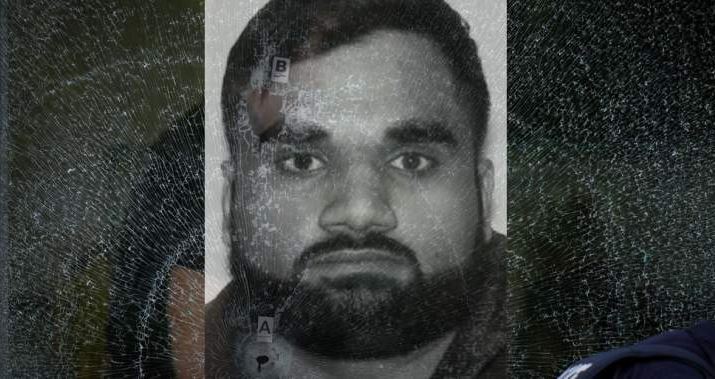 Группировка Бишной | Наш Ванкувер Grayscale portrait of a man with short hair and full beard looking straight at the camera, with a cracked/ distressed overlay across the image.