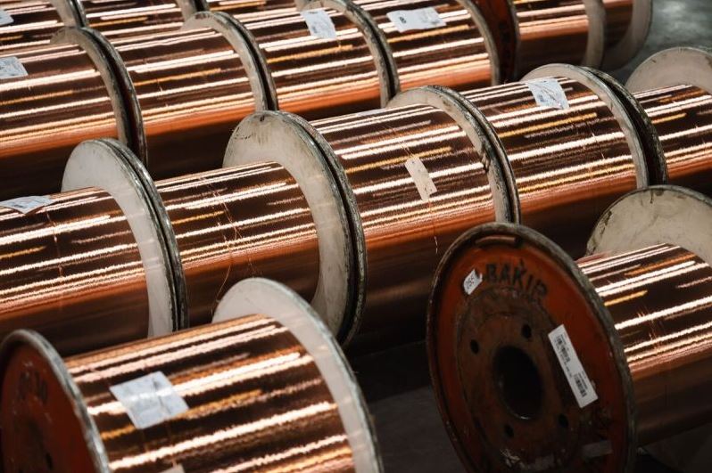 Канада вводит 50-процентные тарифы | Наш Ванкувер Copper wire coils on metal spools stacked in a warehouse.