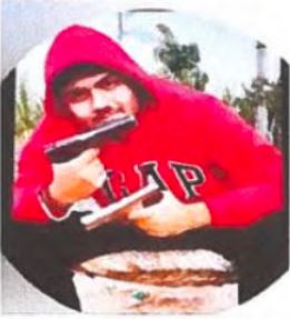 Нони Рана | Наш Ванкувер Young person in a red hoodie pointing two pistols toward the camera in an outdoor setting.