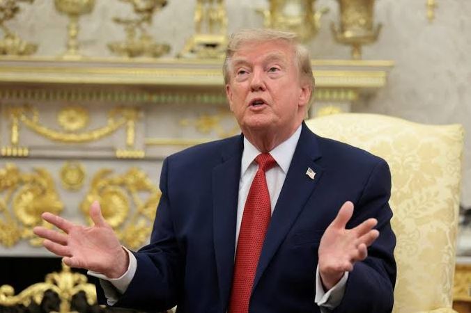 Новые 50-процентные тарифы | Наш Ванкувер Man in a dark suit and red tie sits in an ornate, gold-decorated room, gesturing as he speaks.