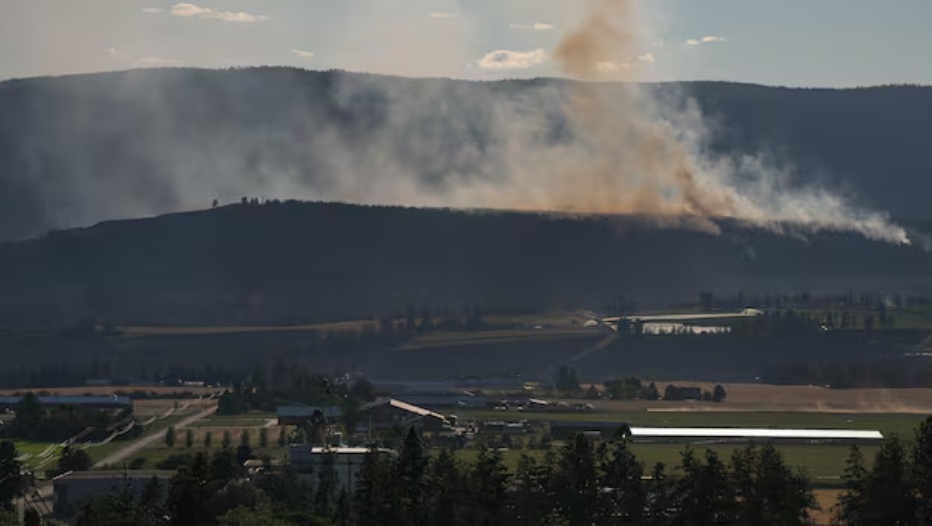 пожары канада пожарф | Наш Ванкувер Smoke plume rising from a hillside over a rural farming valley at dusk/dawn, with fields and buildings in the foreground.