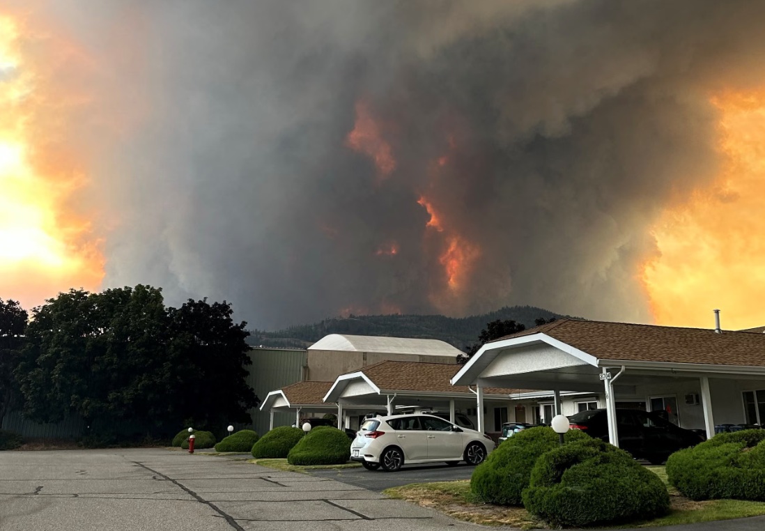 пожары самерленд | Наш Ванкувер Wildfire at sunset behind a residential parking area, with towering smoke and orange flames on the hillsides.