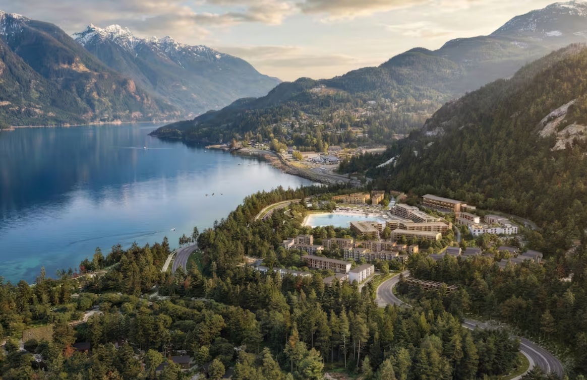 серф парк в ванкувере | Наш Ванкувер Aerial view of a lake surrounded by mountains with a forested hillside and a clustered resort village near the water's edge.