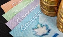 Canadian banknotes fanned out with stacked coins on the right, illustrating money and currency