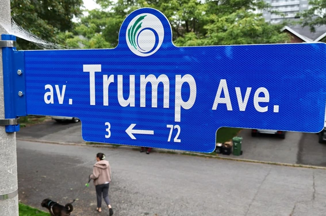 канаде переименовуют трампа | Наш Ванкувер Blue street sign reading 'av. Trump Ave.' with a left-pointing arrow; a person walking a dog is in the background.