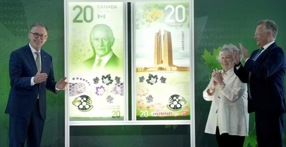 новая купюра в канаде 2027 | Наш Ванкувер Three people in formal attire applaud beside a large display of redesigned Canadian $20 banknotes.