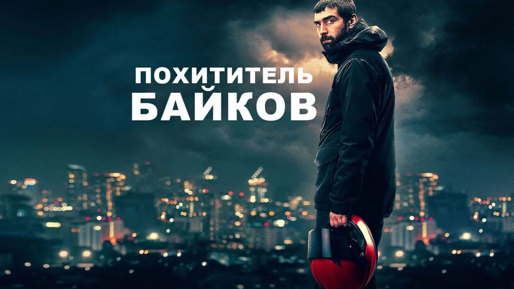 Movie poster: a man in a dark jacket stands at night above a glowing city, holding a red helmet, with bold Cyrillic title text overhead.