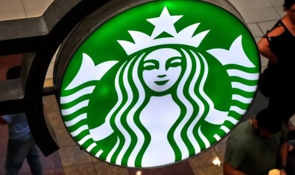 Starbucks logo: white siren on a green circular sign hanging indoors
