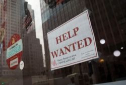 Storefront window with a large 'HELP WANTED' job ad in red letters; smaller bilingual text at the bottom hints Chinese/English availability.