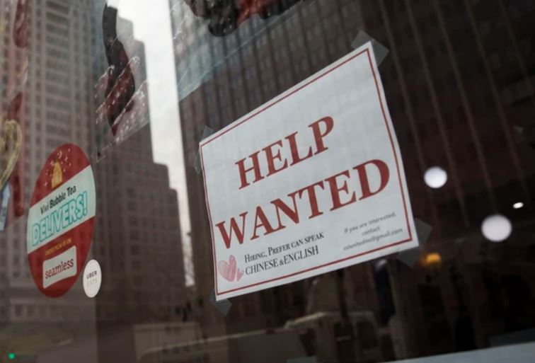 Уровень безработицы в Канаде | Наш Ванкувер Storefront window with a large 'HELP WANTED' job ad in red letters; smaller bilingual text at the bottom hints Chinese/English availability.