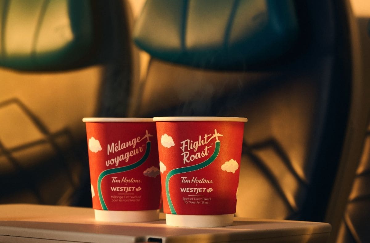 Two red Tim Hortons cups with Flight Roast branding and cloud graphics on a table