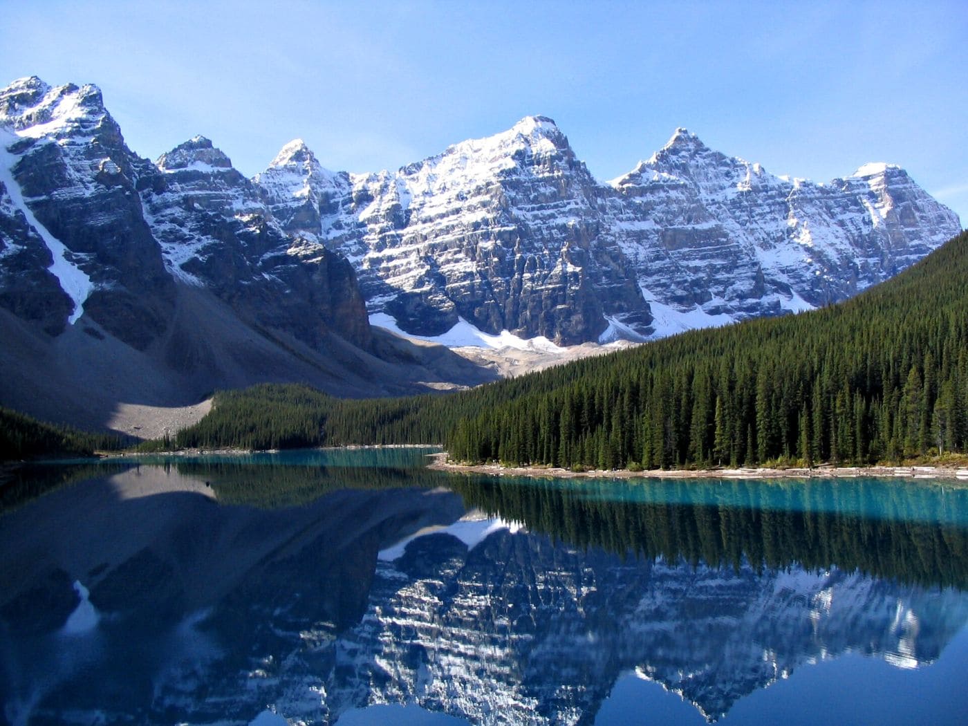 Сотрудник Parks Canada в форменной одежде на фоне горного национального парка в Канаде