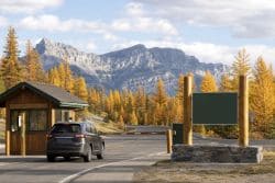 Сотрудник Parks Canada в форменной одежде на фоне горного пейзажа национального парка Канады. Иллюстрация создана ИИ