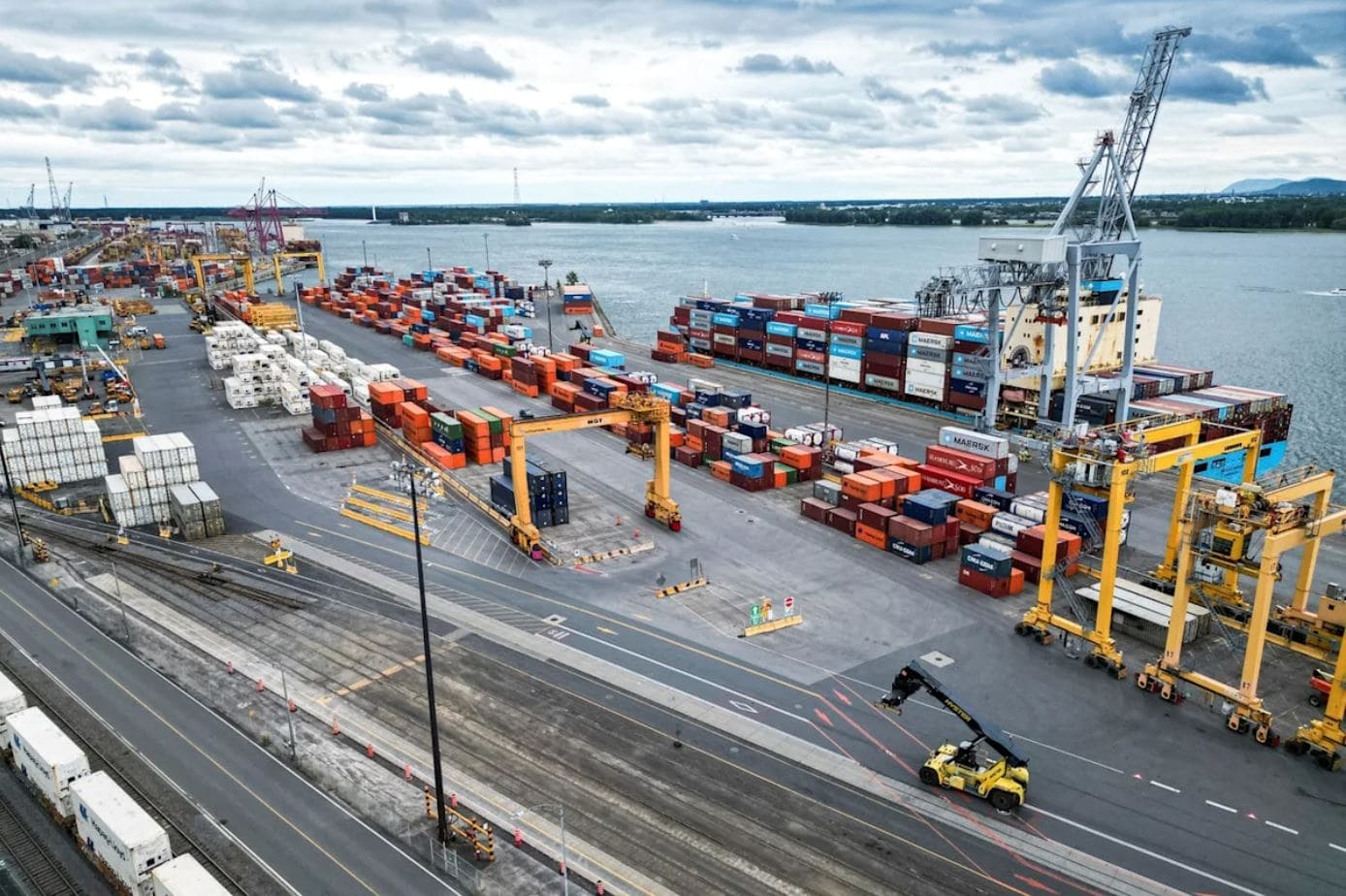 Более половины жителей Канады | Наш Ванкувер Large shipping port with stacked containers, cranes, and a waterway in the background.