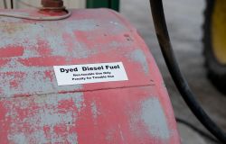 Close-up of a red, weathered fuel tank with a label reading 'Dyed Diesel Fuel — Non-taxable Use Only; Penalty for Taxable Use'