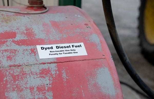 Close-up of a red, weathered fuel tank with a label reading 'Dyed Diesel Fuel — Non-taxable Use Only; Penalty for Taxable Use'