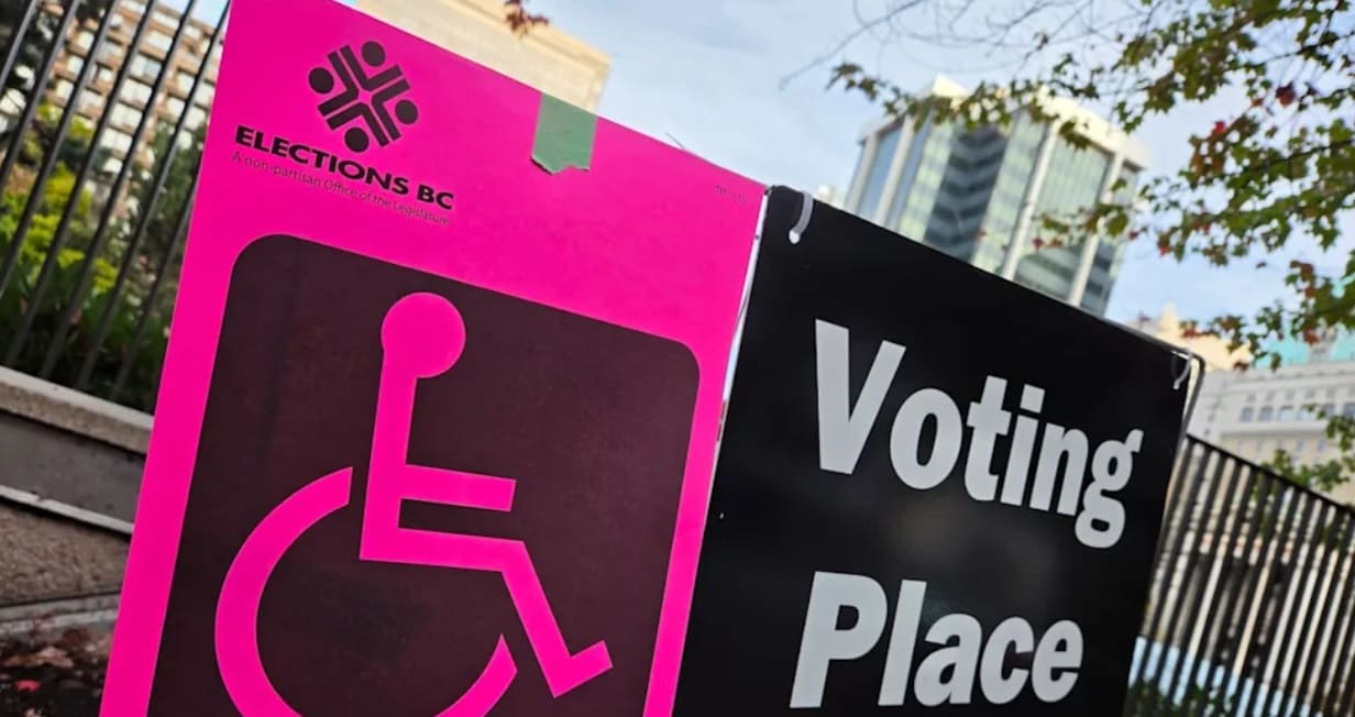низкая явка выборы ванкувер | Наш Ванкувер Voting Place sign featuring a large pink accessibility wheelchair symbol next to a black panel with 'Voting Place' text in outdoor setting