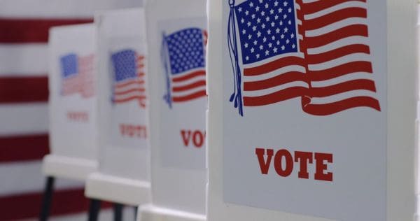 Voting booths with a patriotic graphic and the word VOTE on the front panel.