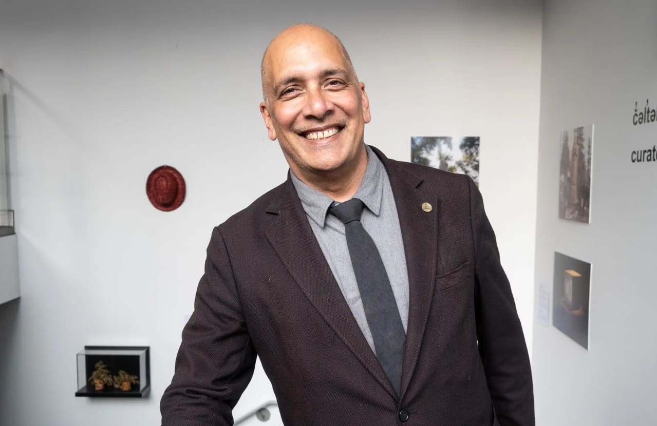 питт фрай мэр ванкувер | Наш Ванкувер Smiling man in a dark blazer and gray shirt standing in a bright gallery space.
