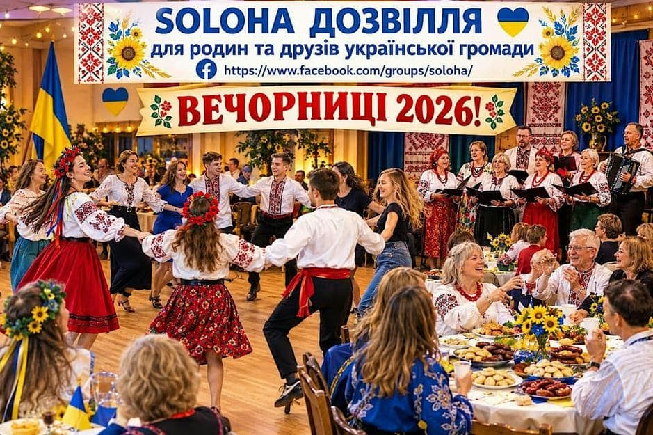 Dancers in traditional Ukrainian outfits forming a circle at a festively decorated hall with banners and tables of food in the foreground.