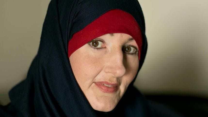 Жительница Британской Колумбии | Наш Ванкувер Close-up portrait of a woman wearing a dark hijab with a red undercap, looking at the camera.