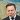 Collage of a man in a dark suit and tie with a world/map background, white outline around the cutout figure