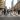 Crowded city crosswalk with pedestrians crossing a wide street amid tall buildings.